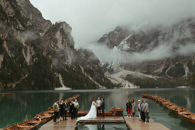 A breathtaking wedding ceremony on a dock, with a lake and mountains providing a stunning backdrop.