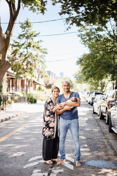 proud parents holding baby next to window