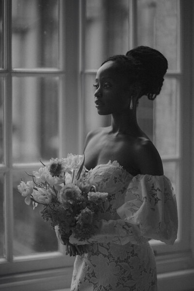 A wedding photographer captures the moment a bride and groom embrace during their first dance outside in the venue grounds.