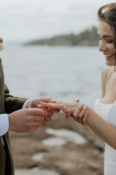 bride and groom exchanging rings on the north shore during their elopement