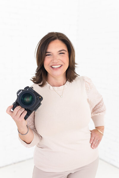 Dallas wedding photographer, Danielle Maggio, smiles with her camera