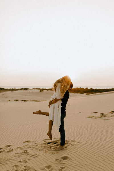 Couple kissing at Silver Lake Sand Dunes in Michigan