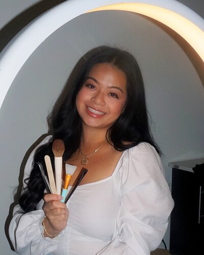 This image features Sothana, a licensed esthetician and makeup artist at Book Sothana, a boutique day spa located at 9303 Baymeadows Rd 105, #120, Jacksonville, FL 32256. Sothana provides customized beauty services including facials, lash extensions, waxing, brow services, and professional makeup artistry for weddings and special events. With a focus on personalized care, expert technique, and creating a calming environment, Book Sothana has become a trusted name in Jacksonville’s beauty community. Holding professional makeup brushes, Sothana symbolizes the artistic and attentive approach she brings to every appointment. Jacksonville clients love the detailed, thoughtful service that elevates their natural beauty and builds confidence. Schedule your facial, waxing, lash, or makeup session today by calling (904) 597-0867 or visiting https://booksothana.com/. Discover personalized beauty care delivered with heart, expertise, and intention at Book Sothana.