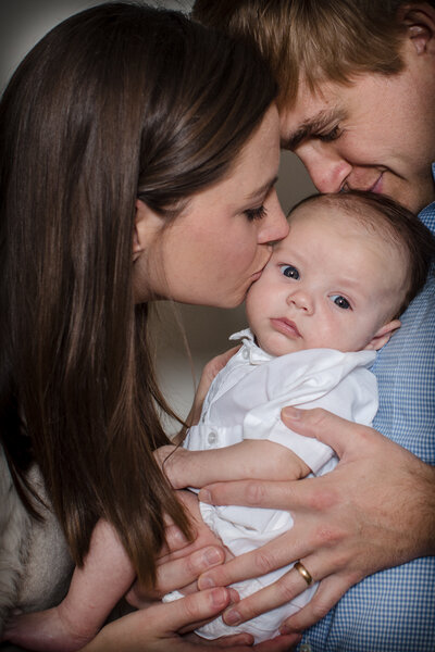 Parents kissing Baby