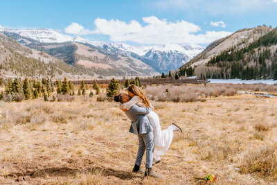 During their summer elopement in Colorado, couple reads vows in front of lake in Telluride