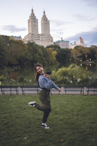 Karen Michelle, Philadelphia wedding photographer, smiling and holding a camera in central park