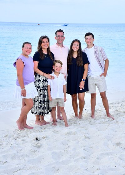 Family poses on the beach during their all-inclusive vacation