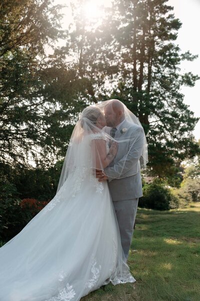 Bride and groom having a kiss during sunset at St.Mary's Church, Northwich
