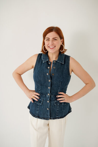 Chelsey Heslop in a denim top and white pants with her hands on her hips