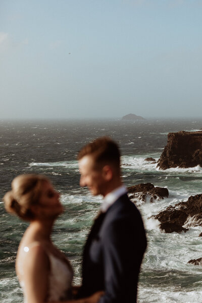 bride and groom embracing on cliff edge