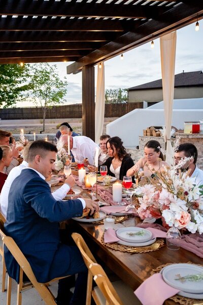 Groom standing behind bride holding her waist as they both laugh