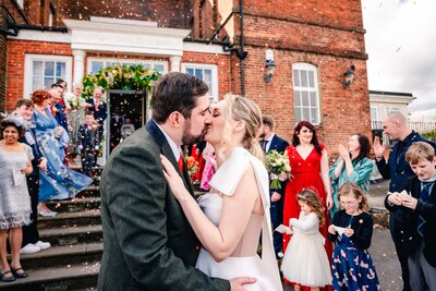 Bride & Groom kissing in confetti