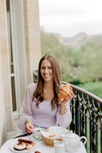Danielle smiling while holding a croissant