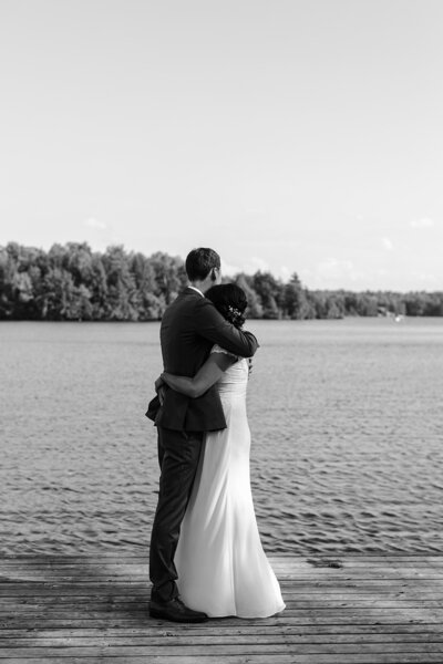 Newly married couple hugging on a dock, after their intimate wedding in Muskoka