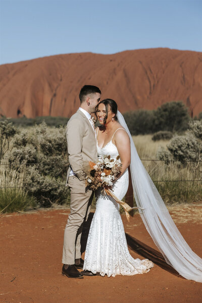 Elopement showing a man and a woman getting married in front of Uluru