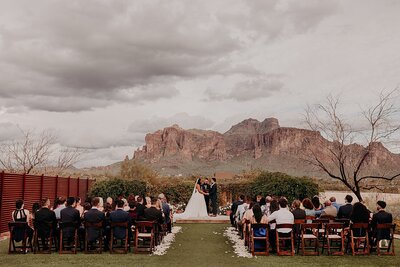Wedding ceremony taking place with desert mountains as the backdrop