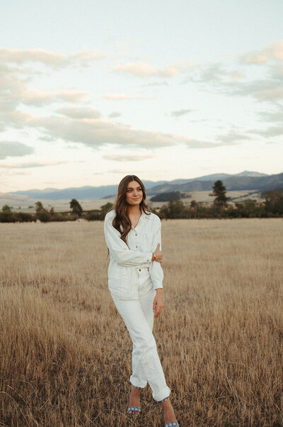 A photo of web designer Rosa Linnell standing in a Montana field, smiling at the camera.