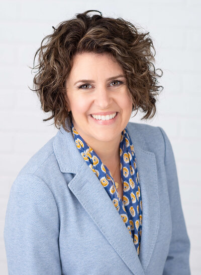 Ottawa headshots of a professional business woman in a blue jacket and curly hair.  Taken by JEMMAN Photography Commercial
