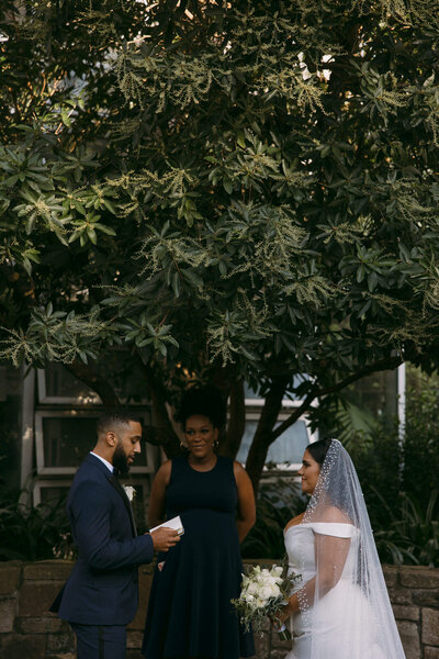 Groom reading his vows to his bride in the middle of the Atlanta Botanical Gardens