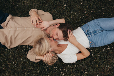Engaged Couple laying down smiling in NH