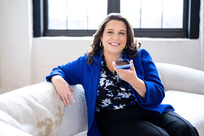 Dr. Chris Limone smiling with arms crossed while wearing a blue blazer, professional portrait on neutral background.