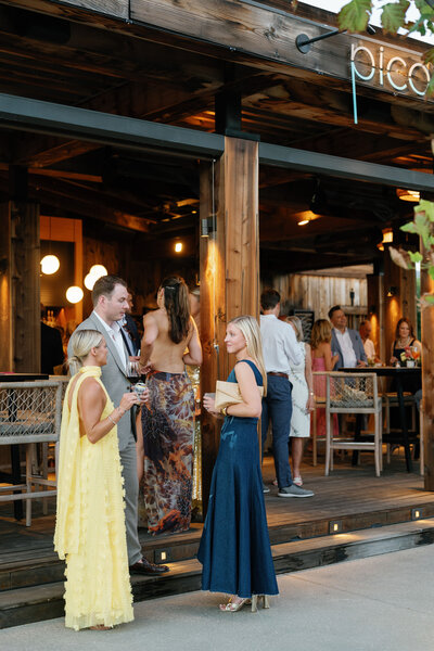 Groom's elegant, green and plum, boutonniere on a white button down and black suit with black tie