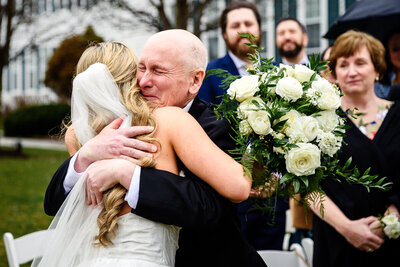 A father hugs his daughter during their wedding ceremony at the Equinox Resort in Manchester, Vermont, captured by Eaton Photo