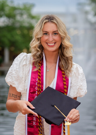 A University of South Carolina student taking her senior portraits on campus in front of the Thomas Cooper Library fountain
