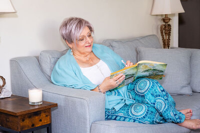 April sits on her couch journaling