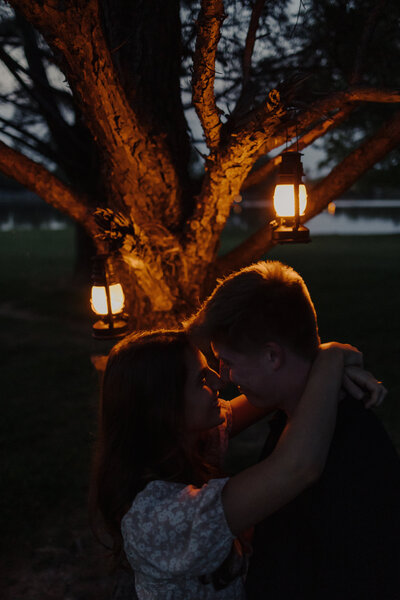 couple close together with lanterns behind them