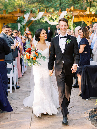 Bride and groom recessing back down the aisle and smiling