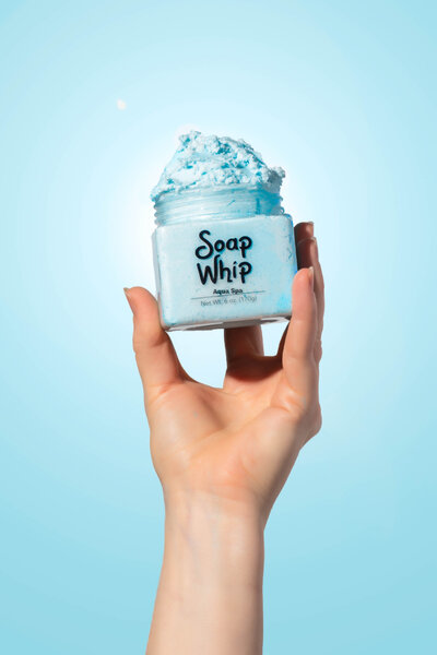 Product photo of blue soap whip held in hand