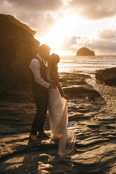 Couple kiss at sunset on the beach in Cornwall