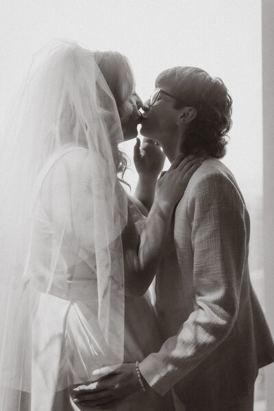 A romantic black-and-white wedding moment featuring a joyful queer couple, captured in an intimate and timeless style.