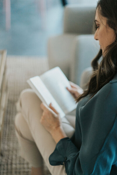 Idit Sharoni reading a book in her office. Contact an online therapist in Florida for support with relationship issues. A couples therapist in Florida can provide the support you deserve.
