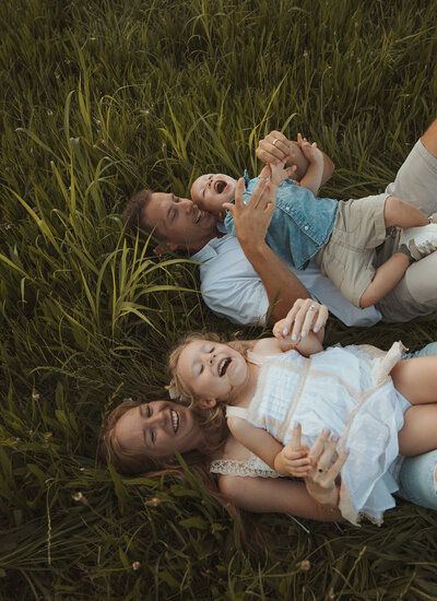 Family playing and laughing together during a sunset photoshoot in Georgia.