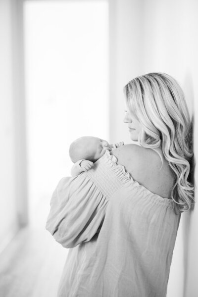 Black & white portrait of mom's back profile looking down at sleeping baby on her shoulder taken by Tampa newborn photographer, Tina Marie Studio