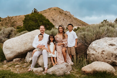 Family of five sitting on boulders at Mayberry Park.
