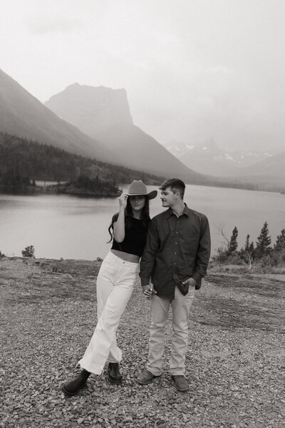 couple hold hands at sun point overlook in glacier