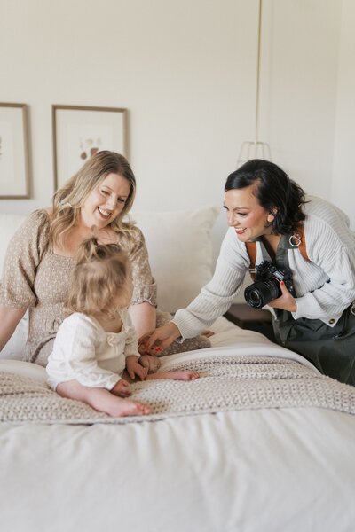 a-photo-of-nashville-family-photographer-dolly-delong-photography-working-with-a-young-family-for-their-family-photos-dolly-is-helping-the-little-one-smile-for-the-camera