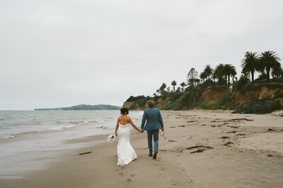 newlyweds walking on beach