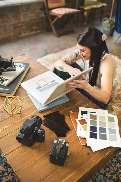 One of the top photographers in baltimore, Nicole Simensky, looking at albums