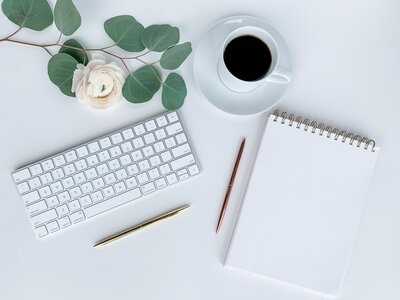 Flatlay image of keyboard and notebook