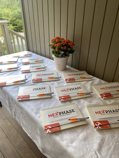 A table setup with branded NexPhase notepads, pens, and décor for a business event.