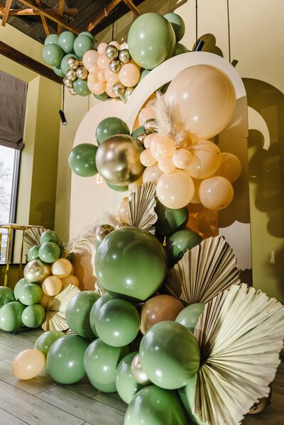 A blue, brown and gold balloon arch.