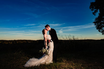 groom dips bride in a meadow at Carolina Country Weddings