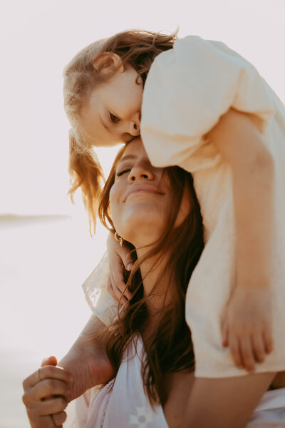 Mother lifting child into the air outdoors, captured by Sydney family photographer Sophie Lea.