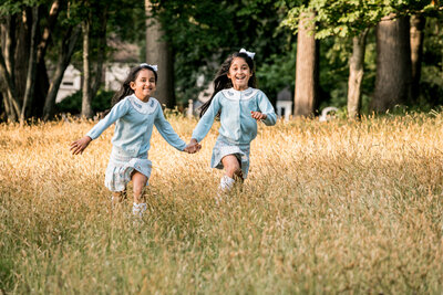 Girls running through the field at their ct family photoshoot