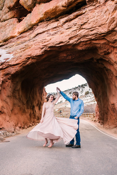 Couple dances for engagement session photos at Red Rocks.
