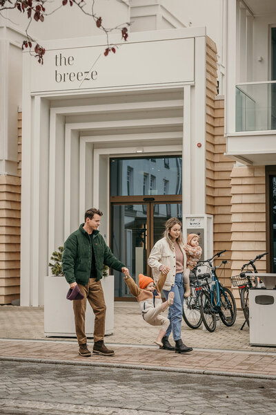 Familie mit Kindern vor dem Eingang des the breeze Hotels.